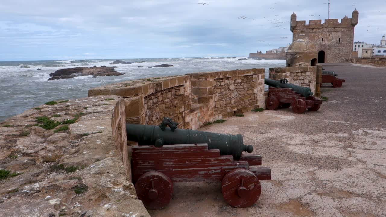 Canons and old castle wall fortified against the stormy Atlantic ocean crashing into the city of Essaouira, Morocco