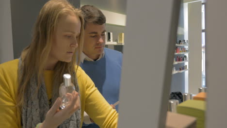 man and woman trying fragrances in perfumery shop