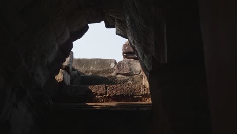 reveal of a hole in the roof inside one of the buildings at the temples of angkor. trucking left, 4k