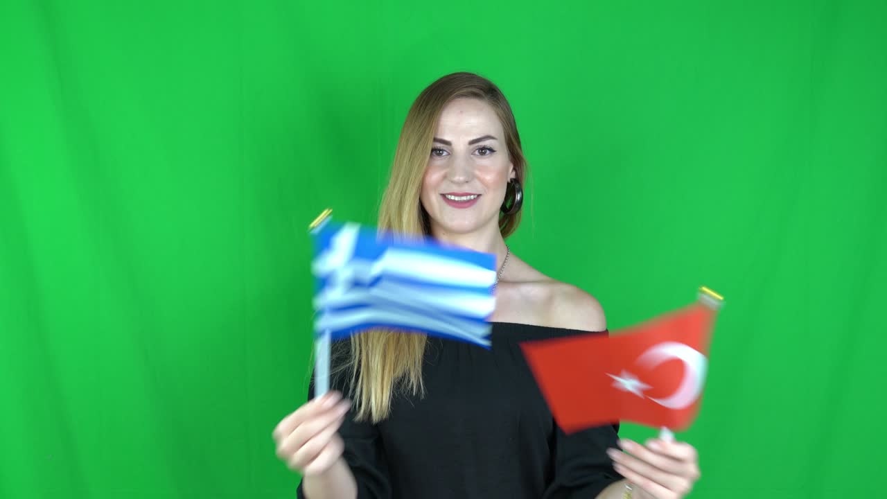 젊은 금발 여성이 그리스 발과 함께 칠면조 발 앞에 흔들고 녹색 화면, 크로마 키 배경