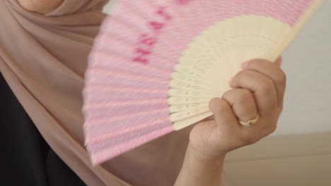 woman with a pink hand fan
