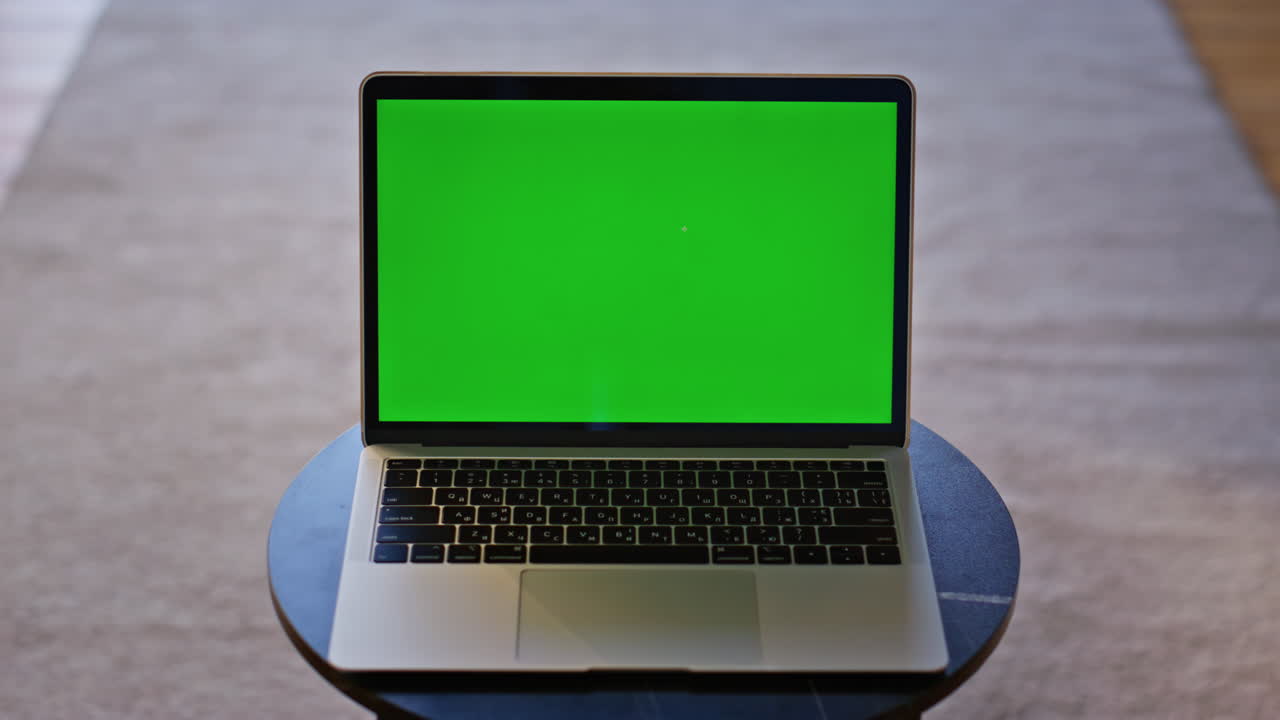 Moderna chroma key per laptop posizionata su un tavolino da caffè vuoto in primo piano. Gadget con green screen