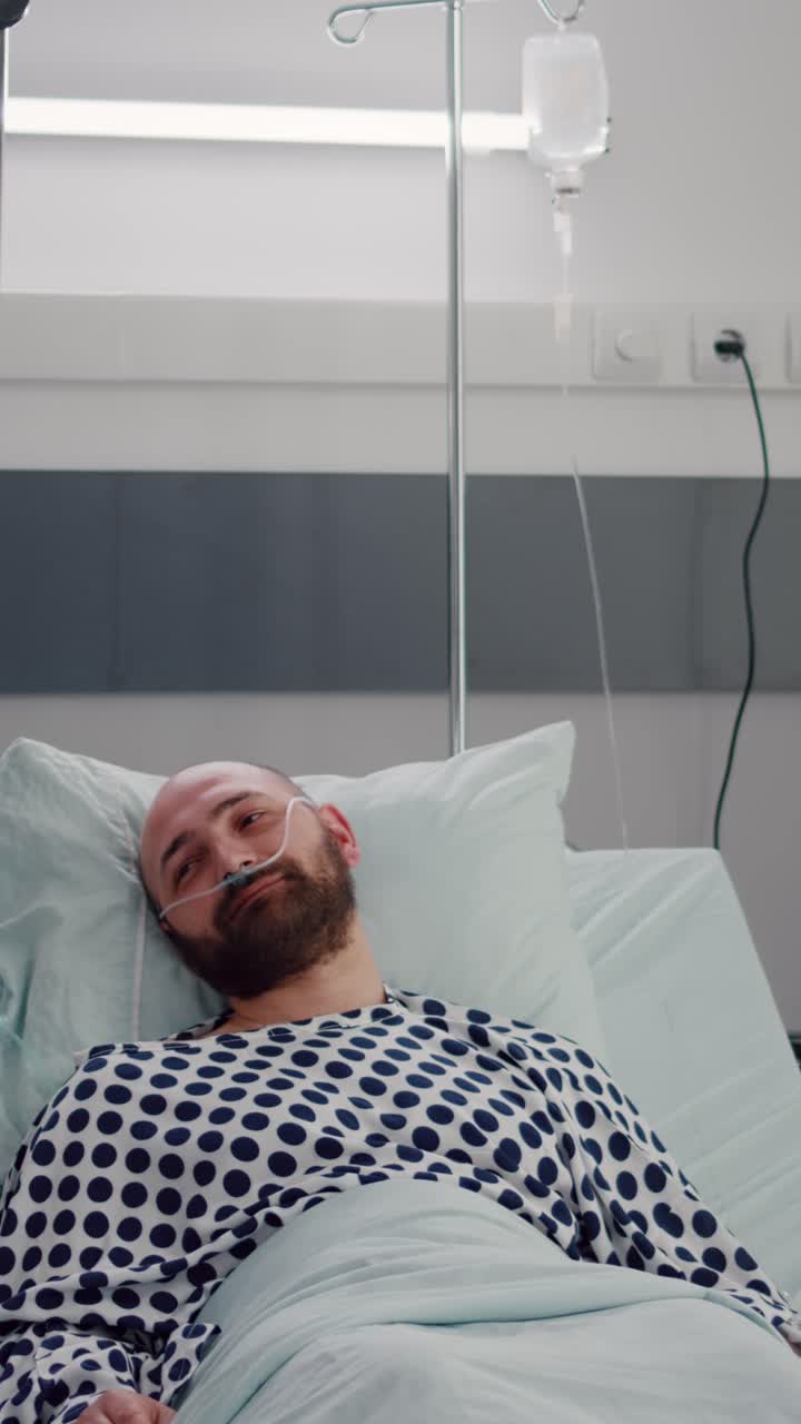 Vertical video: Practitioner doctor monitoring sick man writing disease treatment on clipboard