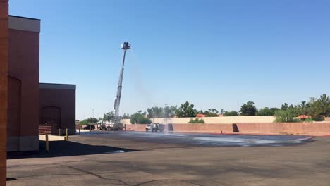 Los-Bomberos-En-La-Parte-Superior-De-La-Escalera-Elevada-Cierran-El-Agua-Proveniente-De-Una-Sola-Manguera-Contra-Incendios