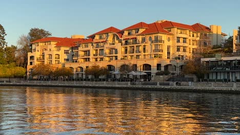 across the water of claisebrook cove to european style apartments in golden sunlight at sunset in east perth redevelopment, western australia