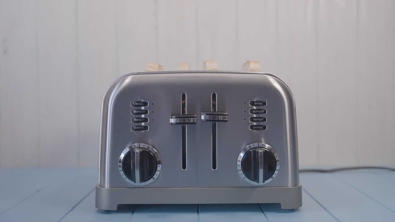 Two Toasted Slices of Sandwich Bread Popping out of Chromed Toaster in the kitchen