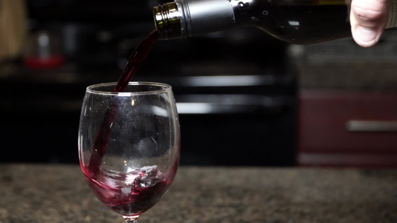 vino a cámara lenta vierte vino tinto en una copa de vino