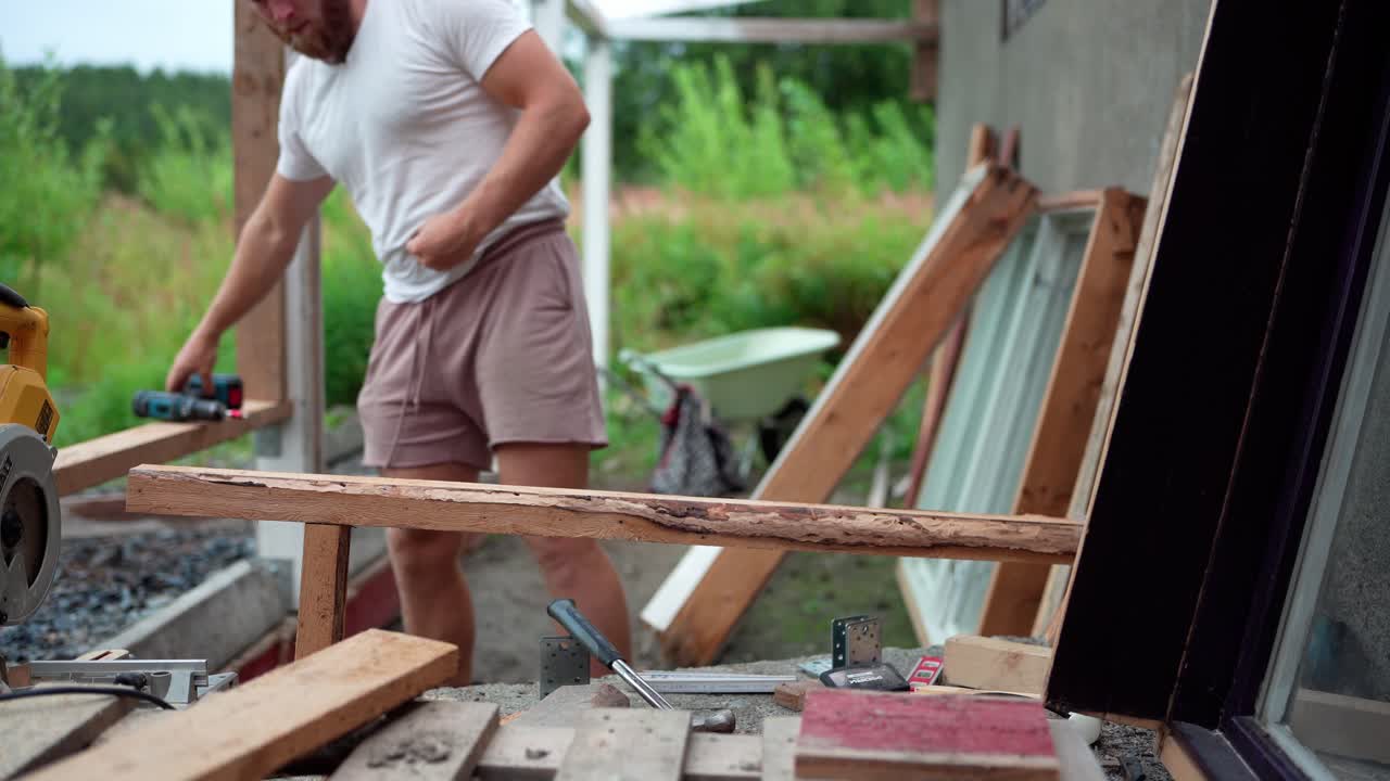 Ein Mann befestigt Nägel in Holz für den Gewächshausbau in Indre Fosen, Norwegen – Nahaufnahme