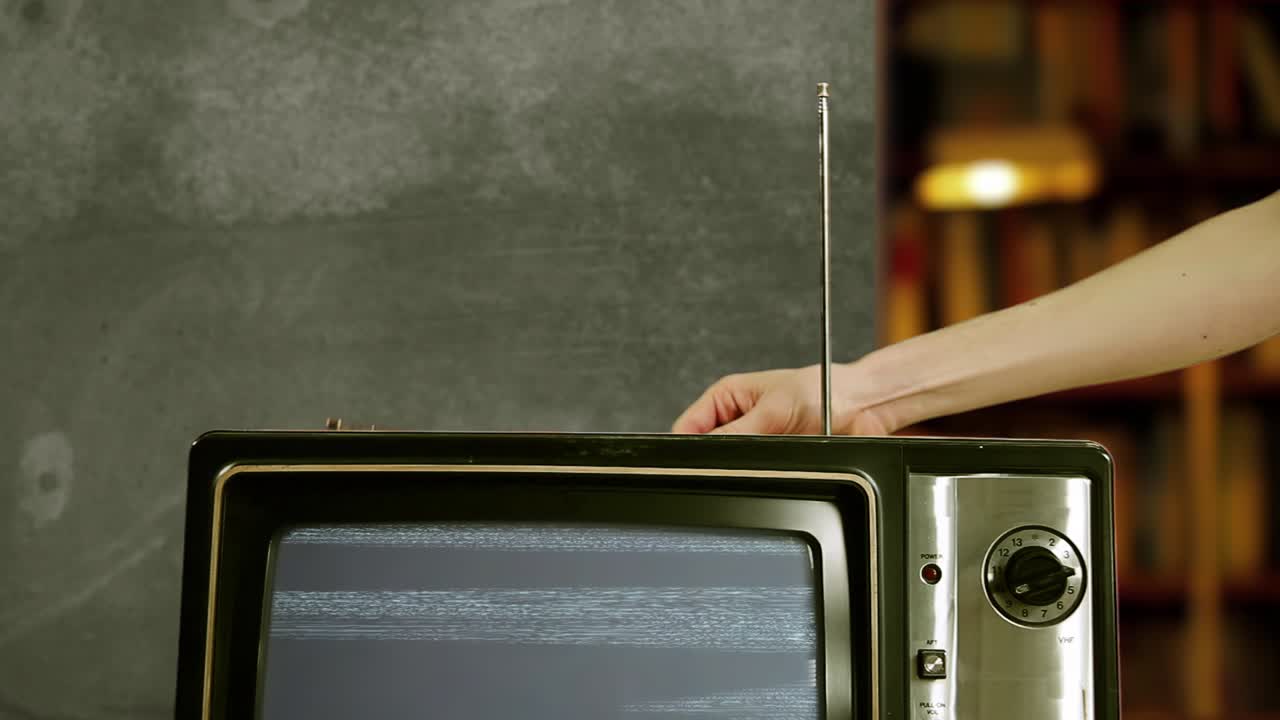 파란 스크린 4k의 오래된 텔레비전 안테나를 손으로 조정하는 남자