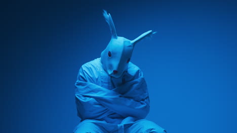 a person in a bunny mask and straitjacket