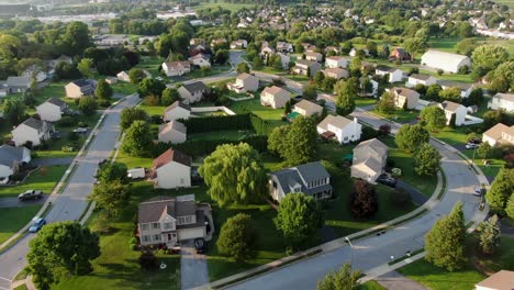 establishing shot, aerial of neighborhood community with two story colonial homes during summer magic hour, housing development in united states of america, usa