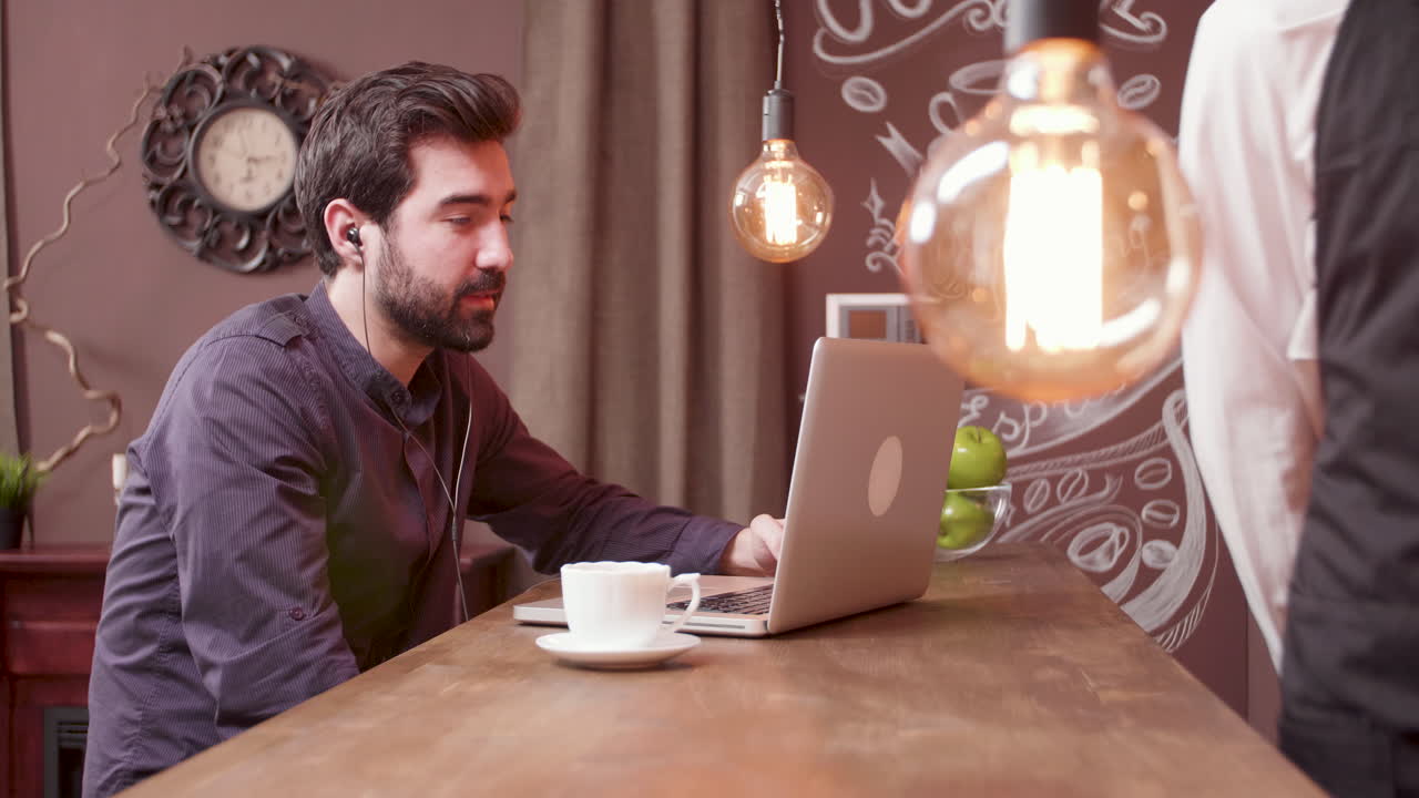 Uomo che lavora al computer portatile nella caffetteria