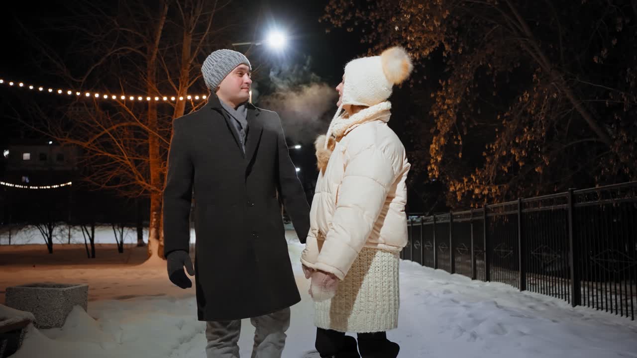 Couple Walking in a Snowy Park at Night