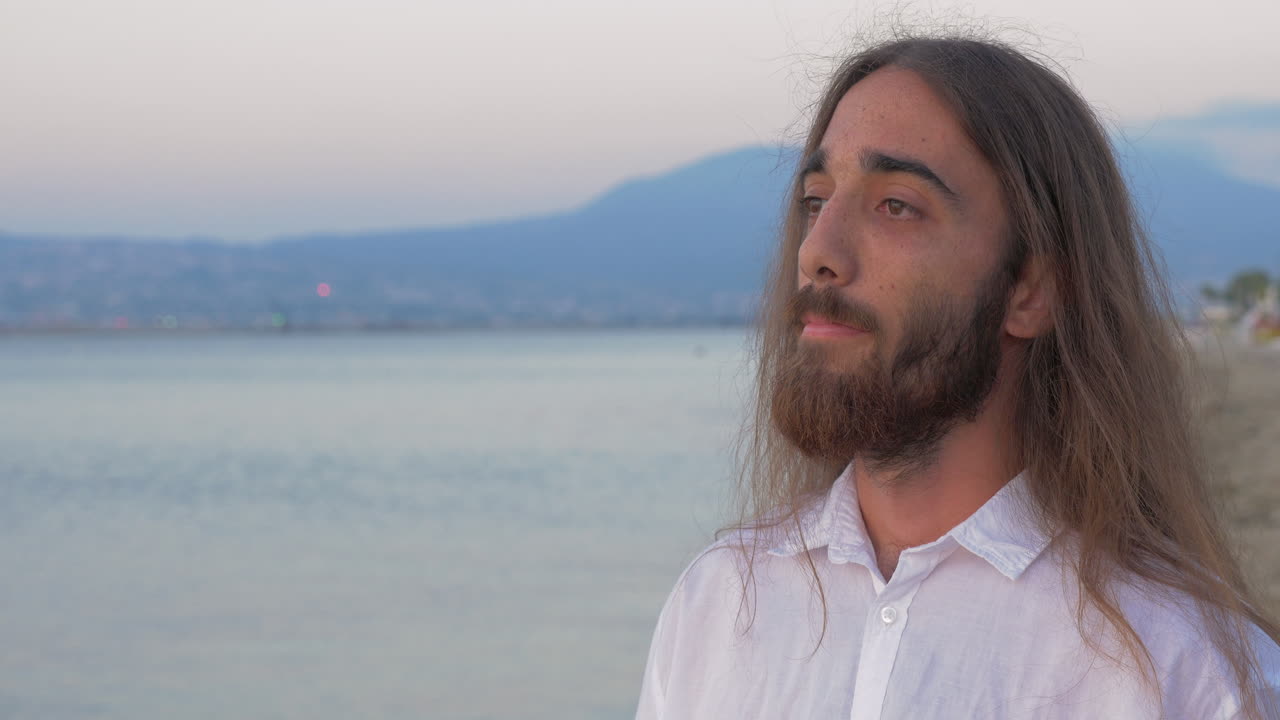 Hombre de pelo largo con barba en la playa