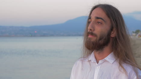 long-haired man with beard on the beach