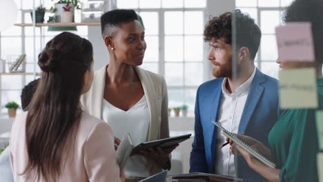 beautiful african american business woman manager meeting with corporate team discussing project sharing creative ideas enjoying teamwork in office workspace