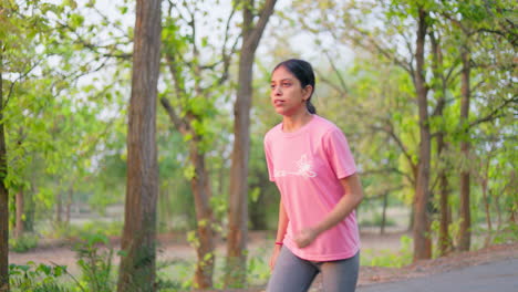 indian woman suffering from knee pain while jogging at outdoor during sunrise