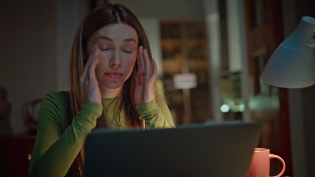 Exhausted woman closing laptop tired of remote work at night home close up.