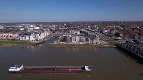 gran buque de carga vacío en primer plano que pasa por el río ijssel frente al barrio de noorderhaven en zutphen, los países bajos, visto desde arriba