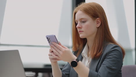 businesswoman with smartwatch and modern mobile phone in office lady is checking notice in app and social media