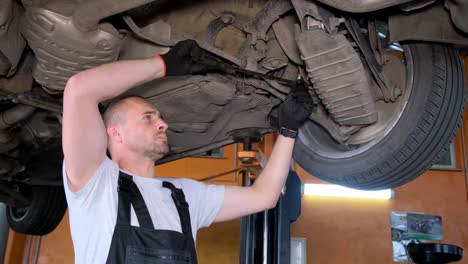 mechanic working on the underside of a car on a lift