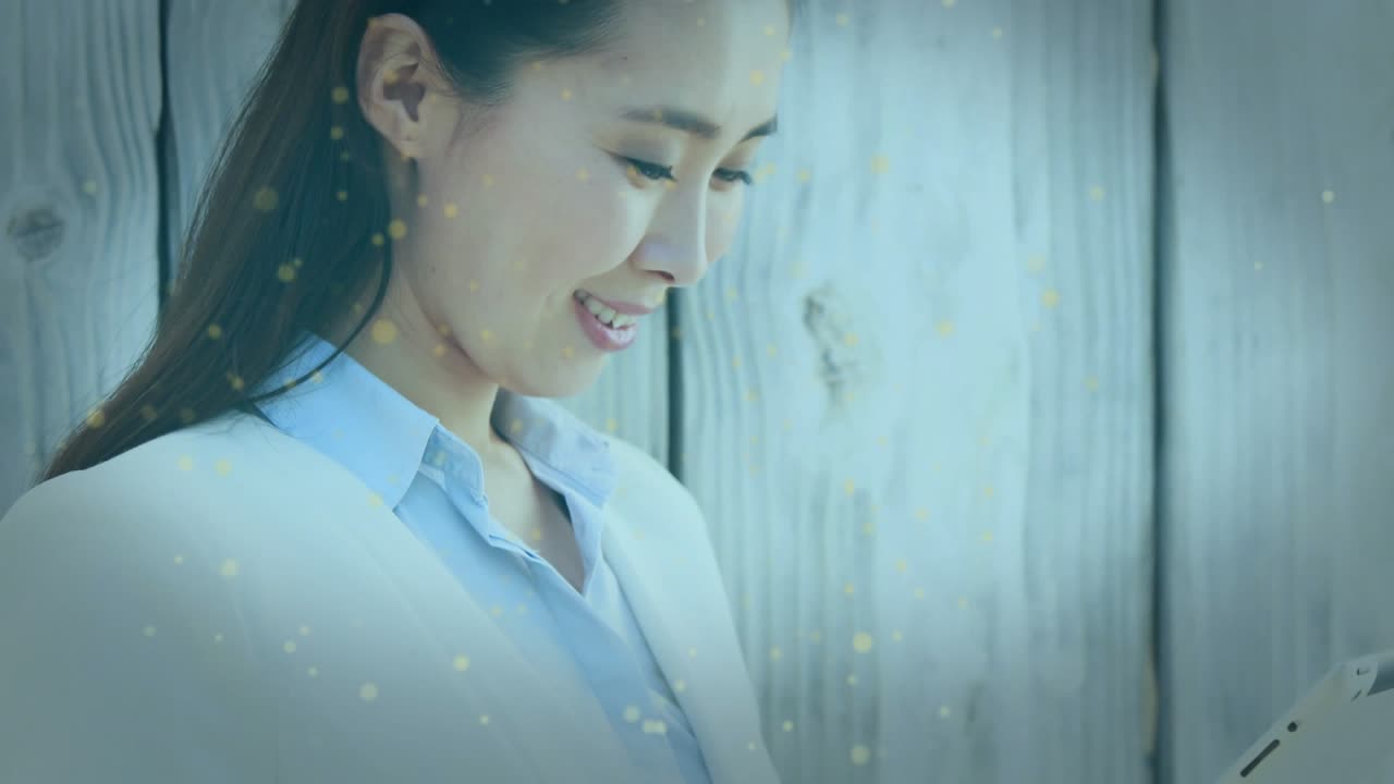 Mid-adult woman tapping tablet and generating animated business chart on wooden backdrop