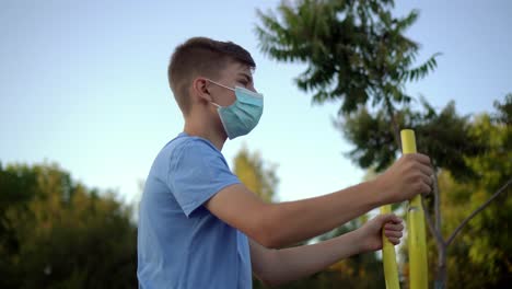 a teenage boy in a medical mask is engaged in sports 05