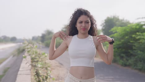 a slow-motion, close-up footage of a young south asian fit woman warming up before jogging in a park in the morning