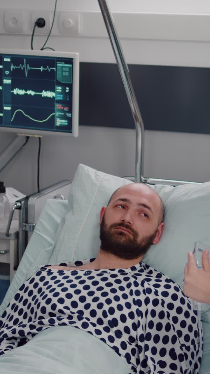 Vertical video: Medical team monitoring heartbeat of sick man during respiratory appointment