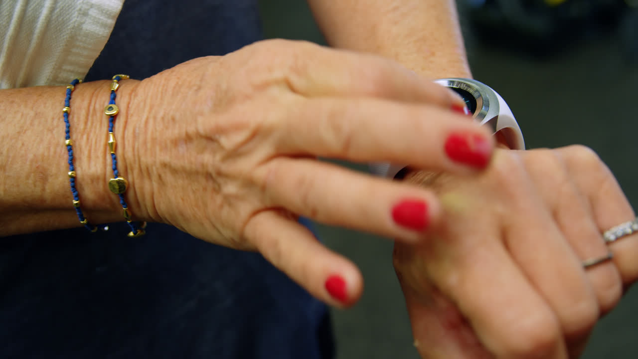 Senhora idosa usando smartwatch na academia 4k