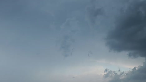 dramatic dark storm clouds fill the sky, creating a moody, overcast atmosphere with varying shades of gray and subtle light breaking through