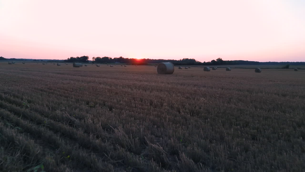 干し草ロール日の出でフィールドの上を飛んで