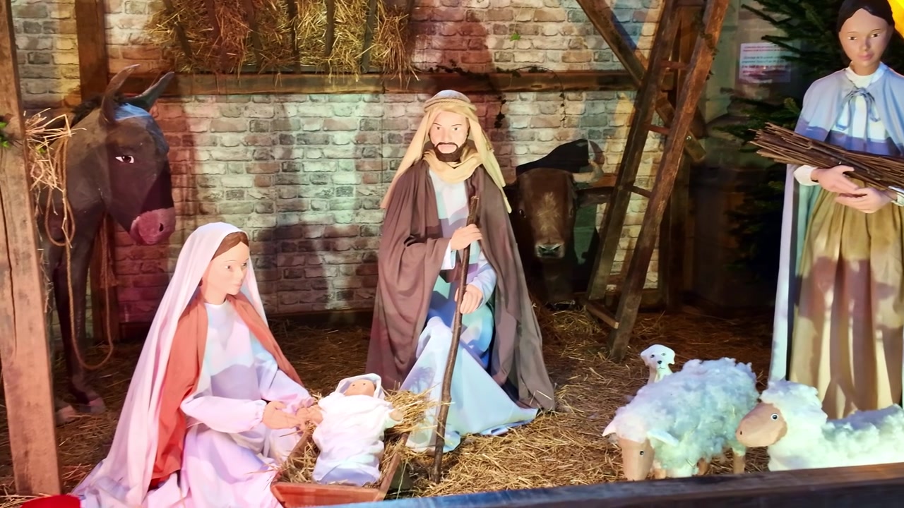 Scène de la Nativité avec Marie, Joseph, l'enfant Jésus, des animaux et des figures de bergers dans une étable.