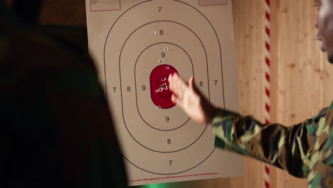 army leader teaches recruits in shooting gallery how to shoot target center