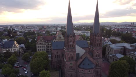 aerial view of catholic church johanneskirche in gothic old town of freiburg im breisgau during sunset, germany