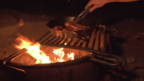 Camping-Barbacoa-Por-La-Noche-Sobre-El-Fuego,-Muslos-De-Pollo-En-Sartén