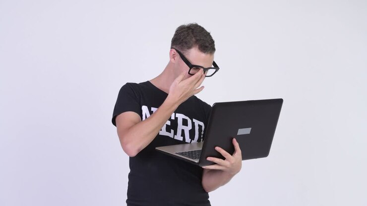 Uomo nerd con gli occhiali che usa il laptop