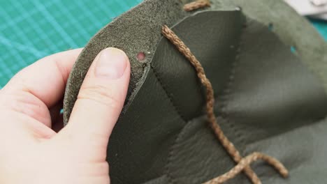 craftsman inserts a drawstring in the sewn pouch