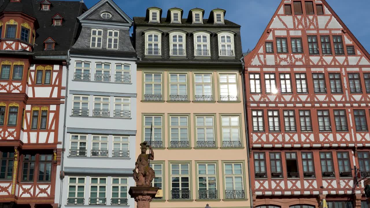 Edifícios históricos coloridos na Praça Römer em Frankfurt com estátua central e arquitetura tradicional em enxaimel na cidade velha