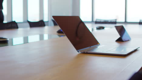 laptop computer and digital tablet on empty boardroom table