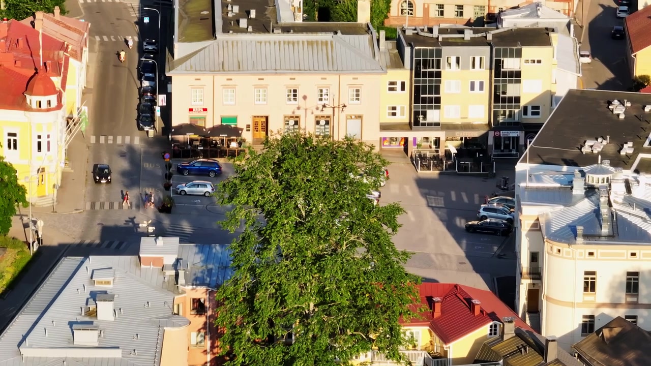Luftfoto med telezoom som sirkler rundt torget i Tammisaari, sommersolnedgang i Finland