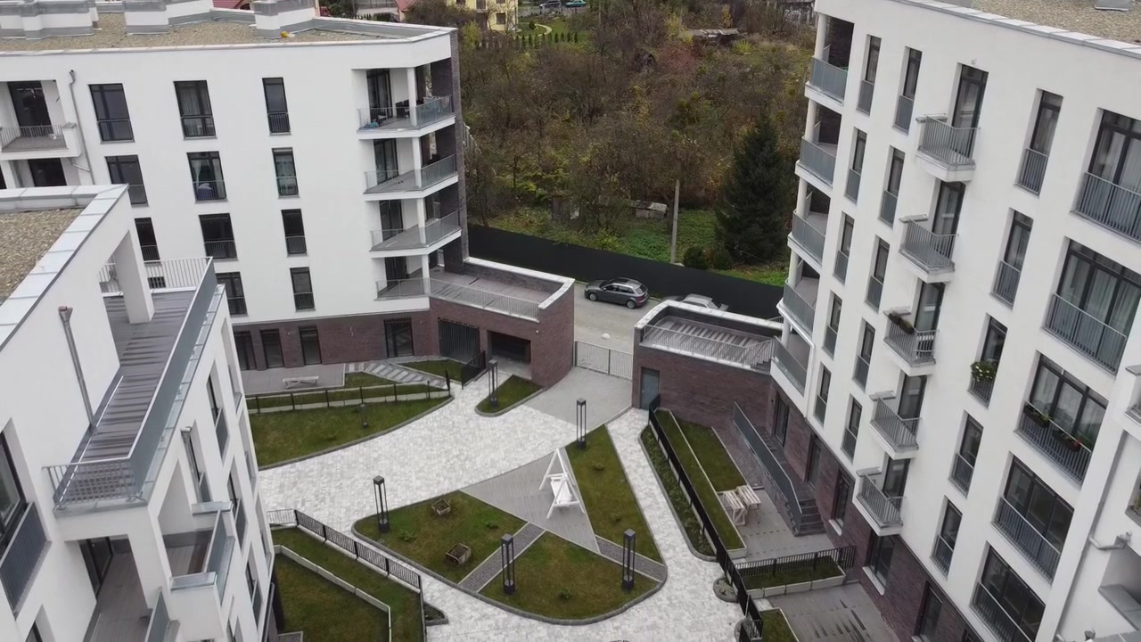 Vista aerea di un drone in volo sopra edifici residenziali, riprese di tetti e architettura.