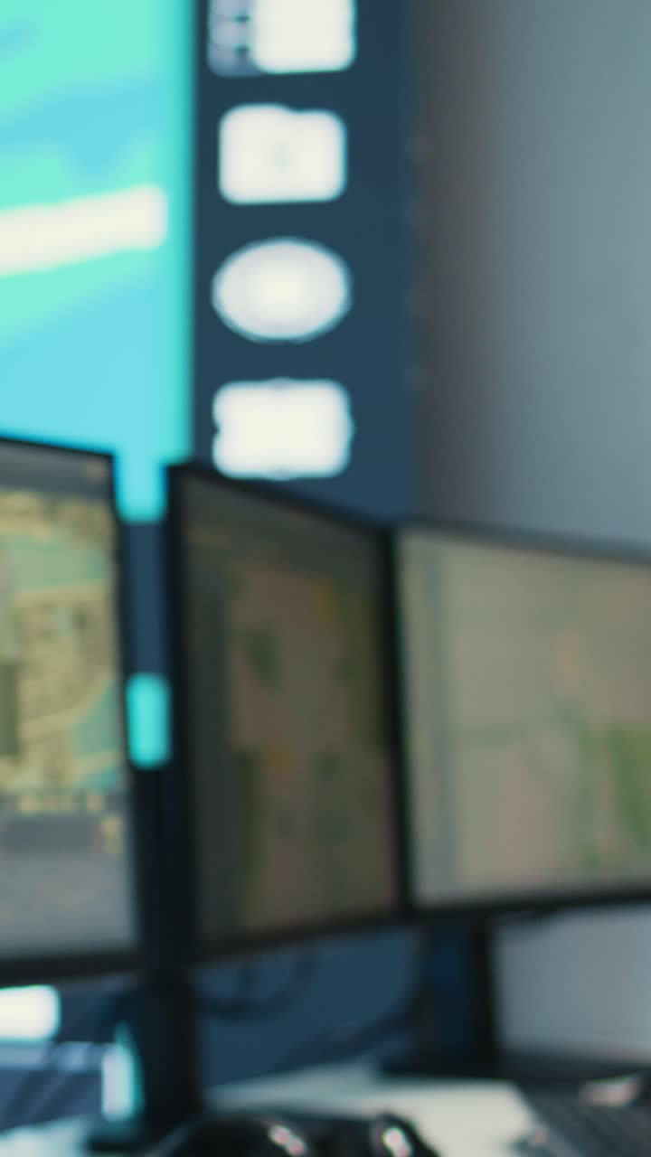 Giovane donna che monitora i dati su diversi schermi di computer in una sala di controllo