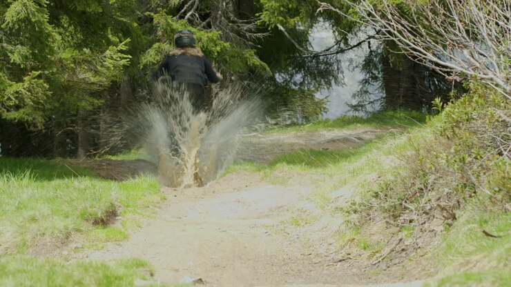Mountain biker splashes multiple puddles at high speed