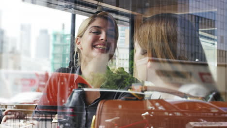 two woman friends sharing coffee in cafe
