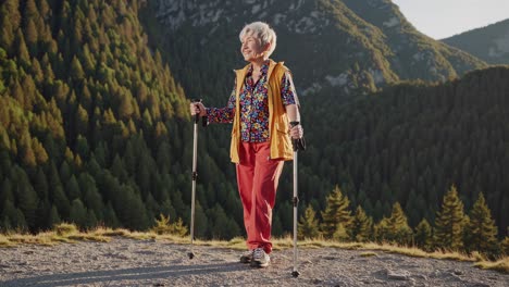 smiling senior woman trekking through majestic mountains with hiking poles, embracing the freedom of a healthy lifestyle on a sunny day surrounded by nature's beauty