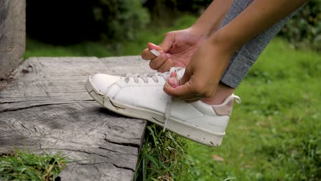 Nahaufnahme-Des-Fußes-Einer-Athletin,-Die-Ihre-Schnürsenkel-Anpasst,-Um-Das-Rennen-Mitten-In-Der-Natur-Zu-Starten