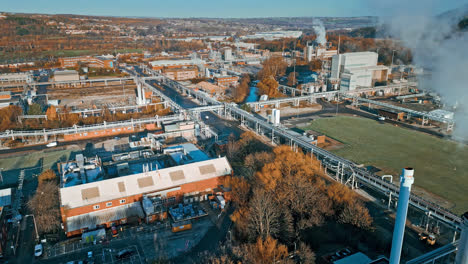 Aerial-footage-moving-towards-a-large-industrial-chemical-plant,-showing-pipelines,-metal-structures,-cooling-towers-and-chemical-storage