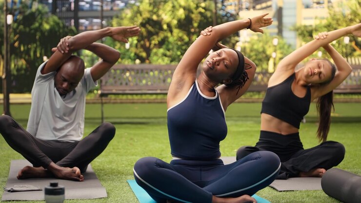 Yoga trainer demonstrating raised arms side stretch and deep breathing