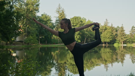 Young-Woman-Yoga-position,-Stretching-by-the-lake,-warm-up